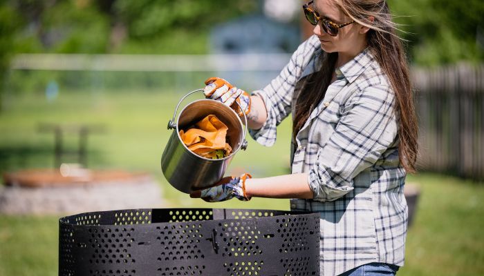 woman adding food scraps to composter